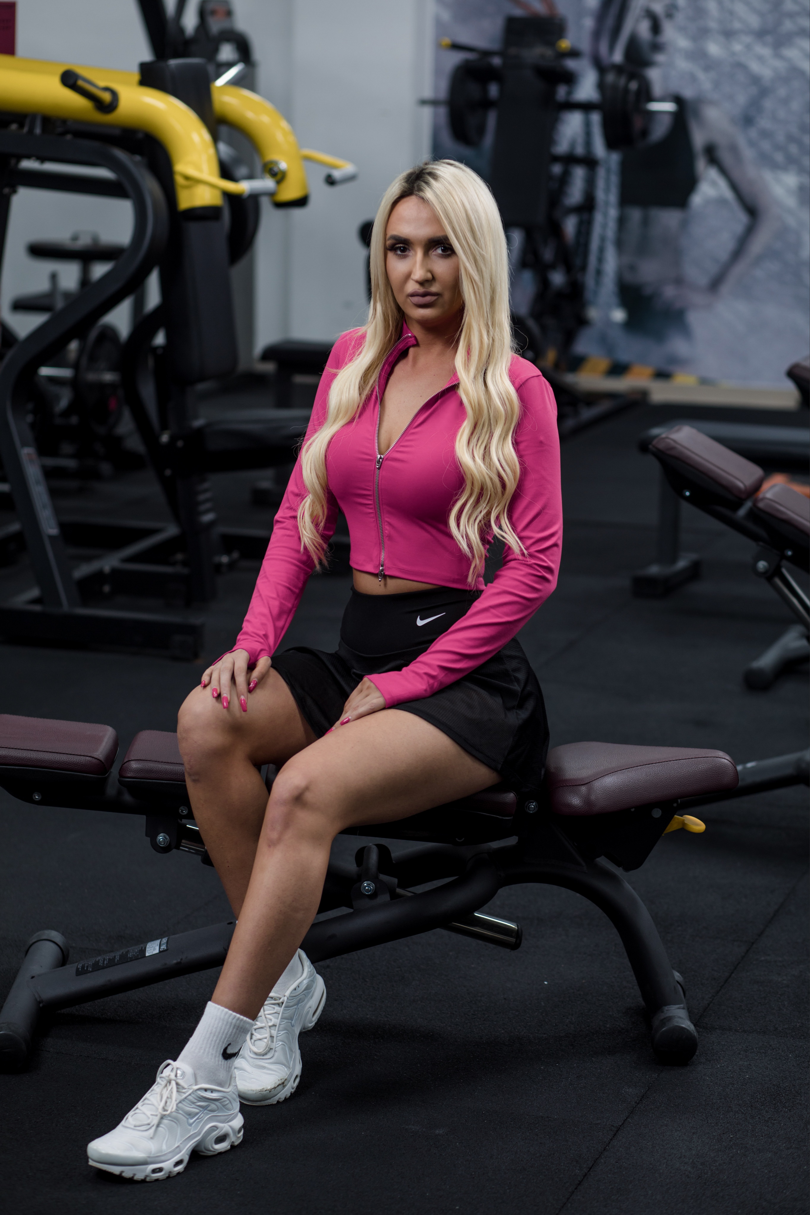 Monika Gajić, personalni trener, u sportskoj opremi, stoji u teretani sa opremom u pozadini